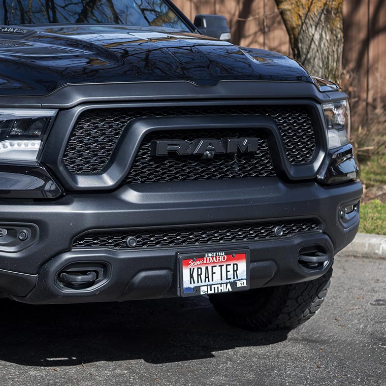 Close-up of a black truck front with a visible Idaho license plate.